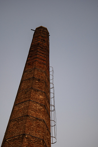 Industrial exterior of abandoned factory with smoke stack, sky  background with copy space, full frame horizontal composition