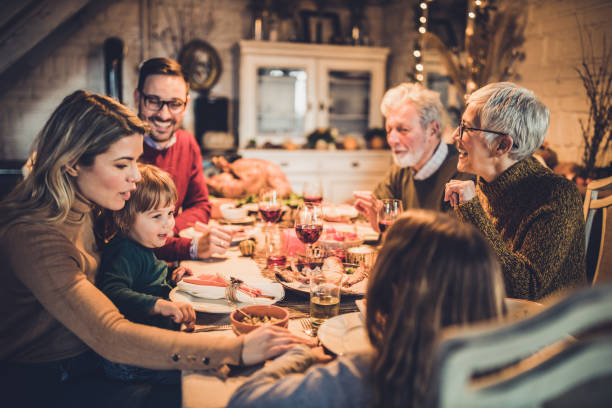 istock Happy multi-generation family communicating while having Thanksgiving lunch in dining room. 1744005362