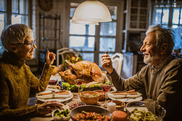 istock Happy senior couple talking on Thanksgiving lunch at dining table. 1744008027
