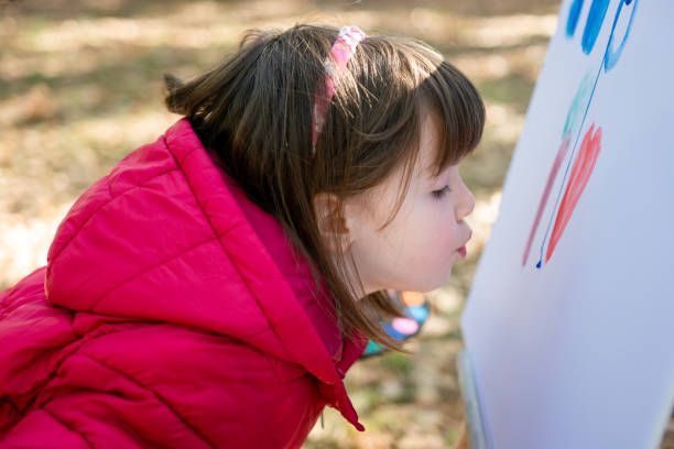 istock Child having fun to be creative while painting on easel in the nature 1744056541