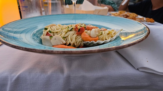 Italian spaghetti with a fish sauce dressing on a plate at a seafood restaurant