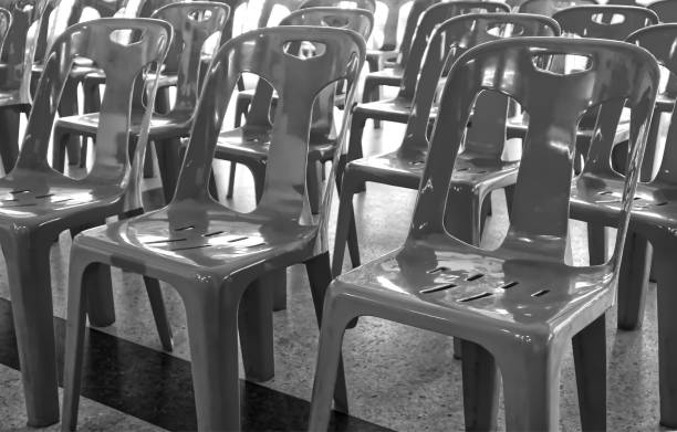 istock Black and white, Group of plastic chairs in natural light, background 1744073062