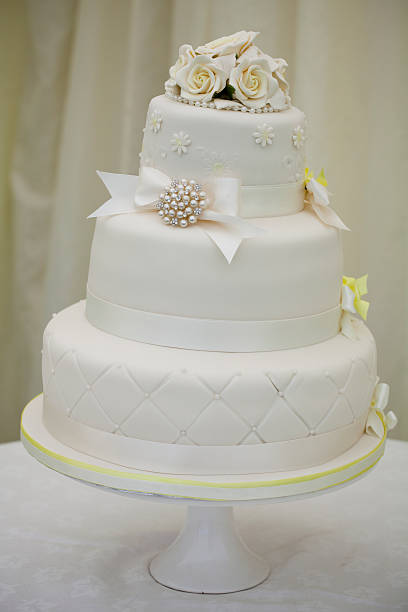 istock Wedding Cake White With Yellow Trim, Roses and Bows 174407430