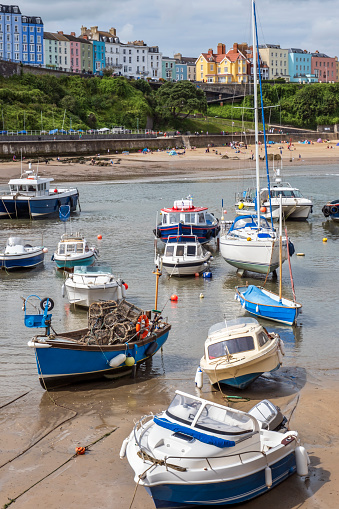 Boats moored in Tenby harbour at low tide in summer, Pembrokeshire Coast National Park in Wales.