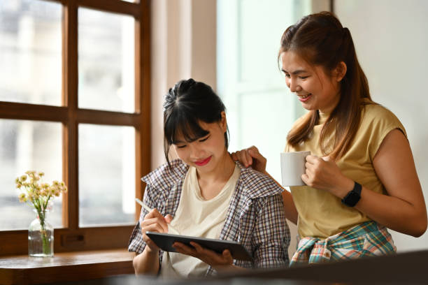 istock Two young woman using digital tablet and having a discussion during a coffee break in office 1744149241