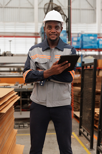 Portrait African American man worker smile and confident holding a digital tablet in factory