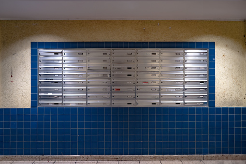 East Berlin communist era apartment block's blue mail room/boxes at night