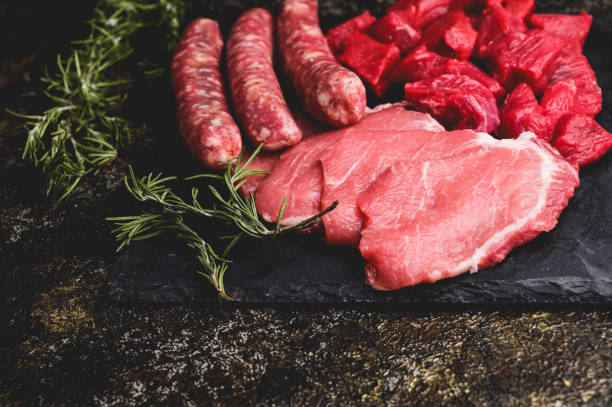 Various cuts of red raw meats on a table.