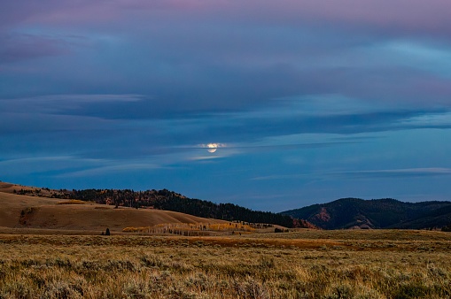 The moon peeking through the clouds on a cool autumn night in Jackson Hole, Wyoming.