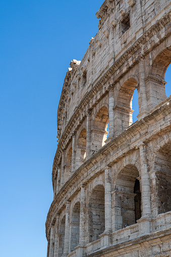 close up of Colosseum, Rome, Italy with blue summer sky behind it - portrait