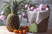 Christmas tree toys in a basket and an elegant decorated pineapple. Preparation for the New Year