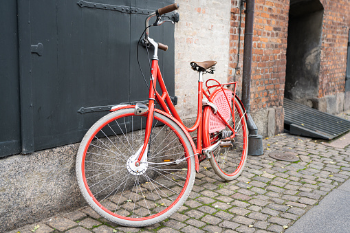 old red vintage bicycle parked on cobblestone street in Copenhagen