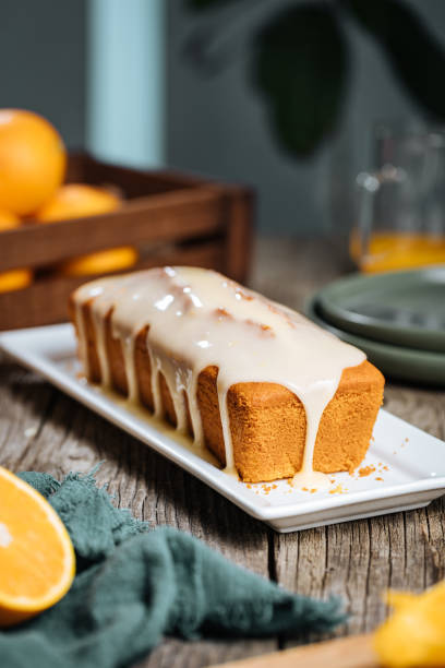 istock Popular sponge dessert called Pound cake with white glazing, served with oranges on rustic wooden background 1744194440