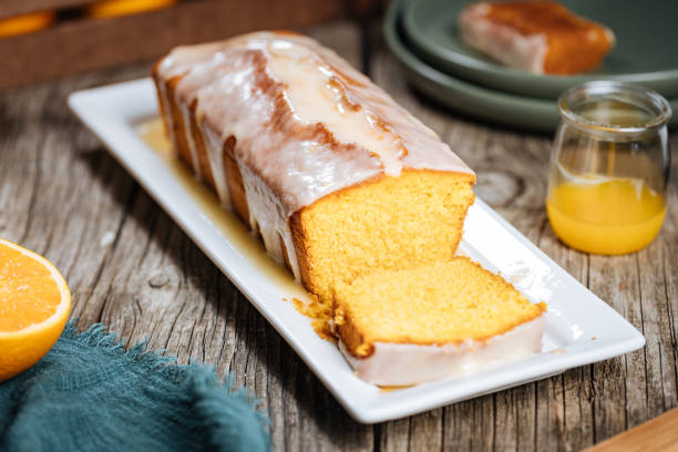 istock Popular sponge dessert called Pound cake with white glazing, served with oranges on rustic wooden background 1744194462