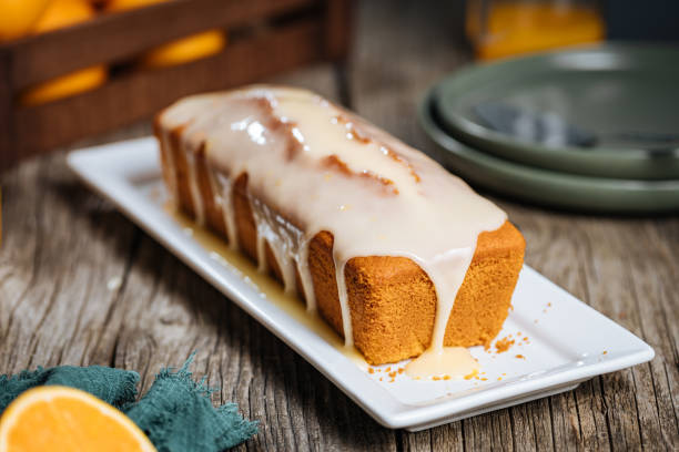 istock Popular sponge dessert called Pound cake with white glazing, served with oranges on rustic wooden background 1744194463