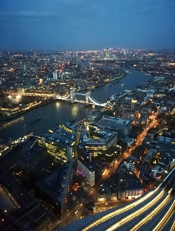 The view from the top of The Shard in London is nothing short of spectacular. From this vantage point, you're treated to a breathtaking birds-eye view of the city. The urban landscape sparkles with a myriad of city lights, casting a mesmerizing glow across the metropolis. Iconic landmarks like the Tower Bridge stand tall and elegant, their architectural beauty illuminated against the backdrop of the meandering River Thames. This extraordinary vista is a testament to the majesty of London's skyline, a captivating blend of modern skyscrapers and historic structures, and it's a must-see for anyone looking to experience the city's grandeur.