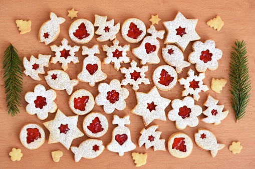 Various shapes of Linzer cookies filled with strawberry jam. Christmas baking