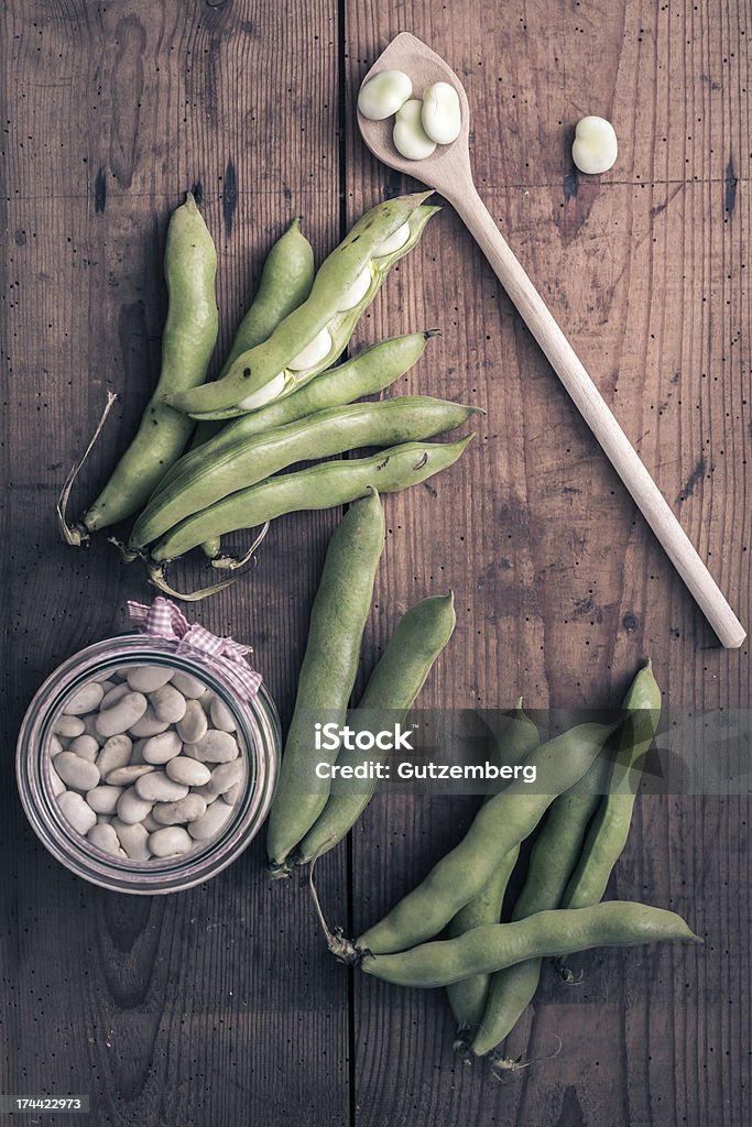 Ampia di fagioli su un tavolo in legno con vaso - Foto stock royalty-free di Fagioli cannellini