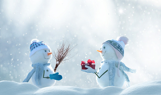 Merry Christmas and happy New Year greeting card with copy-space. Snow background. Two cheerful friends snowmen standing in winter  landscape