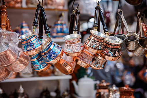 Traditional metal souvenirs at souvenir shop. Copper coffee mugs. Eastern authentic oriental cups. Grand Bazaar in Istanbul, Turkey.