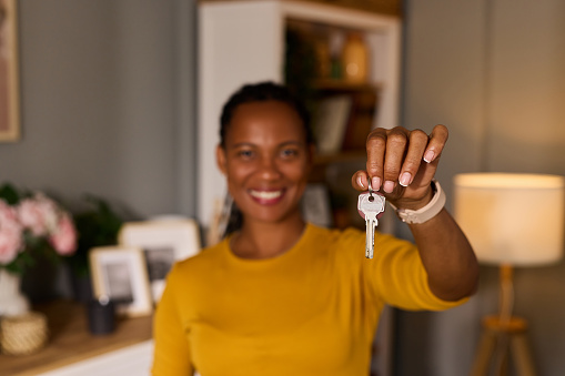 Happy woman holding up the keys to her new home