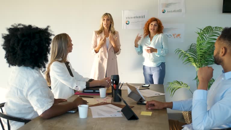 Company CEO talking with sign language translator for inclusion in a meeting.