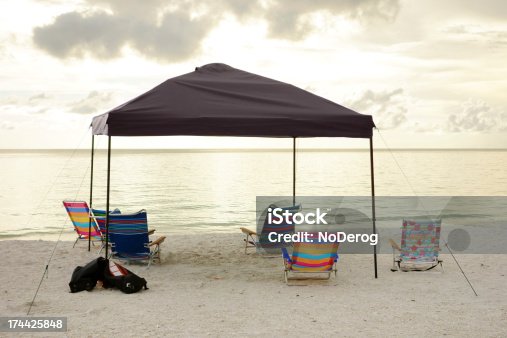 istock Empty beach chairs under tent canopy 174425848