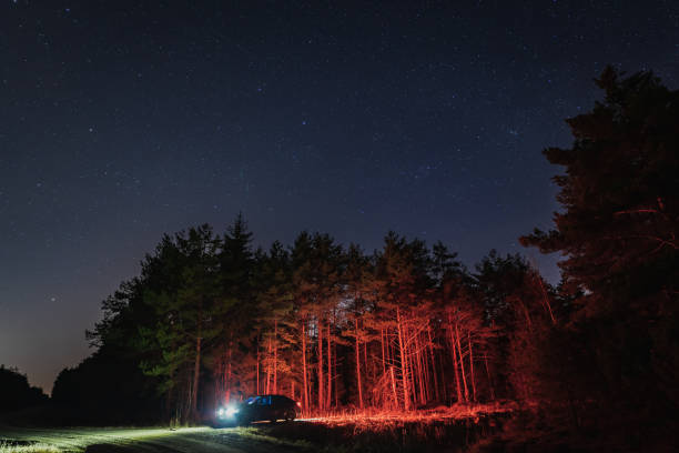 istock A car with headlights on in the forest at night with a starry sky. 1744265247