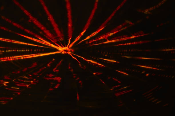 Retouched image in which thin red-yellow light streaks spread out like ripples, like fireworks reflected on the water surface.