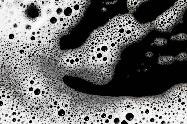 istock Soap bubbles texture. Black teflon frying pan cleaning. White suds pattern. Liquid detergent foam. 1744287783