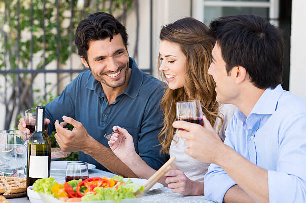 istock Young smiling people sitting at table outdoors 174429001