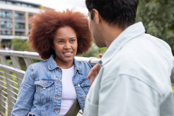 istock Young couple standing by railings in a town and talking 1744306139