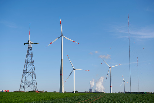 Broken prototype of a wind turbine beside four conventional types, Germany.