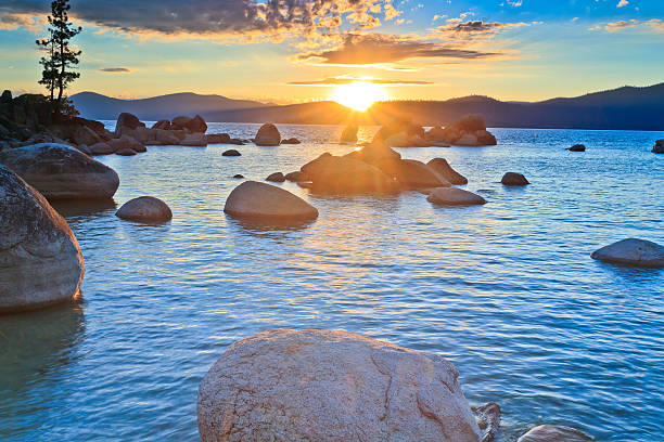 istock Sunset over mountains, rocks, and rippling water 174431823