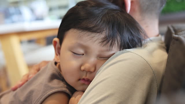 Little Boy Sleeping On His Dad Shoulder.