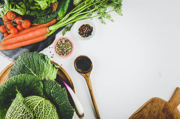 raw salad ingredients on a white wooden table with copy space.