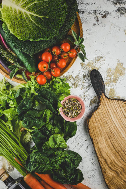 istock cooking background. Raw green vegetables on a table with cutting board. 1744326876
