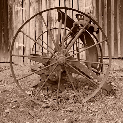 A sepia-toned shot of an antique wheel