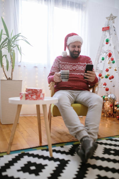 istock Man using mobil phone at home for Christmas 1744350154