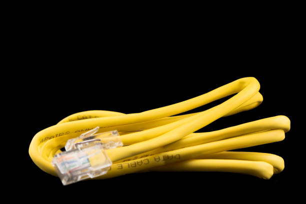 internet data cable isolated on black background. internet communication concept. network internet yellow cable isolated over black with clipping path. ethernet cable. network cable - data technology computer cable power line imagens e fotografias de stock