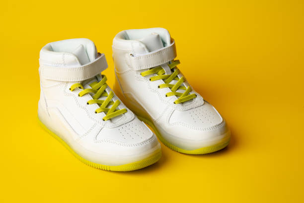 istock White sneakers with yellow neon laces on yellow background 1744364847