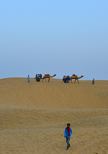 Jaisalmer, India - Nov 8, 2017. Riding camel on Thar Desert in Jaisalmer, India. Thar Desert is a large arid region in the northwestern part of the Indian.