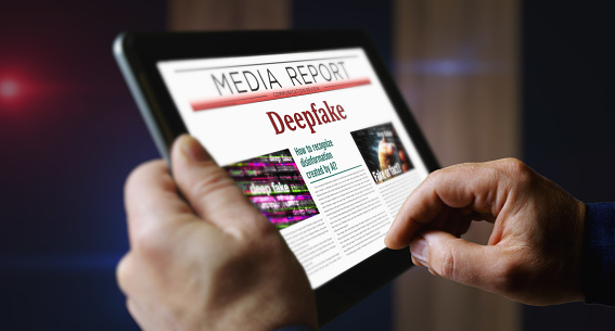 Deepfake, IA, desinformación, noticias falsas, periódico en la pantalla de la tableta móvil photo