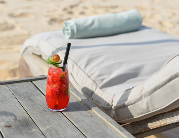 istock Glass of fruit juice on a beach table 1744374034