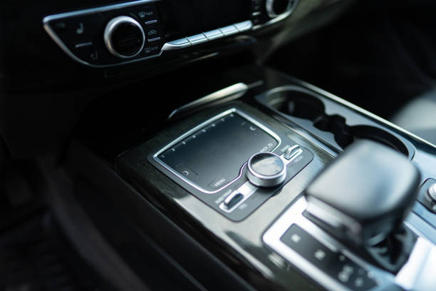 istock Focus on round pushbutton control of multi media interface with touchpad on center console of luxury car. Tactile sensor being activated by fingers 1744381831