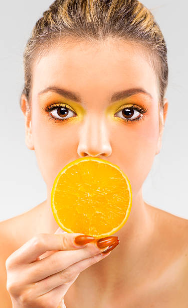 istock Woman close up with a orange slice 174438360