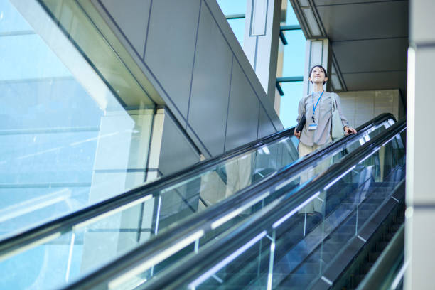 istock Business woman riding an escalator 1744384720