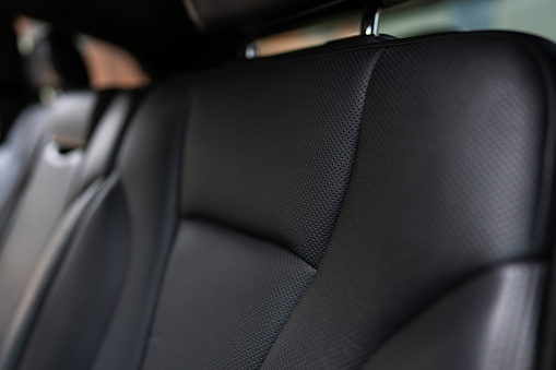 Close up view of rear seats in expensive vehicle covered by refined leather upholstery. Four-way lumbar support for passengers' comfort. High quality photo