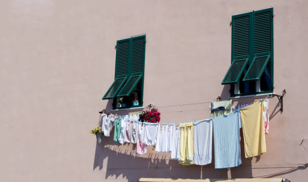 istock Washed clothes drying on a clothesline outside windows with green wooden shutters copy space 1744392463