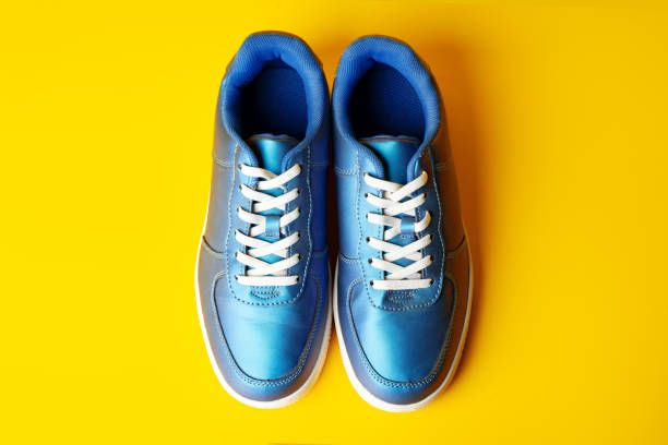 Blue new sneakers on yellow studio background close up
